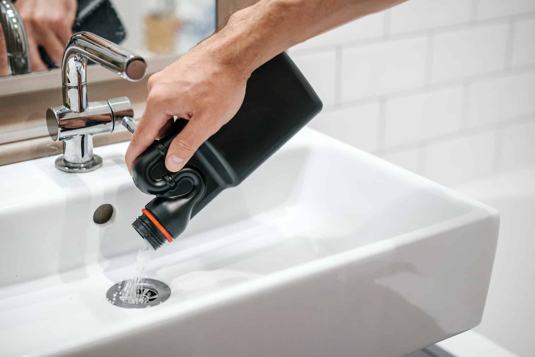 Liquid drain cleaner being pored down a sink